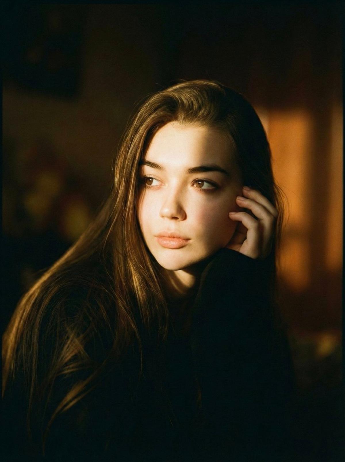 A cinematic portrait of a person is sitting in soft dramatic