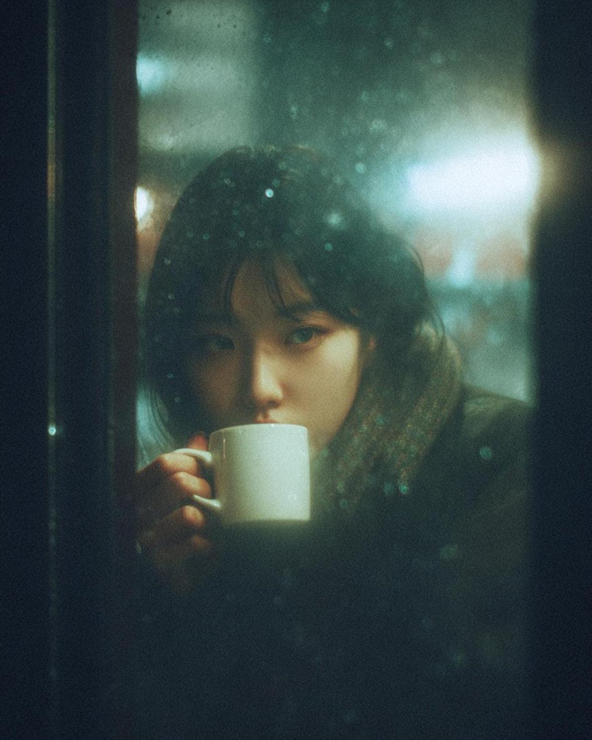 A cinematic, moody photograph of a young woman sitting insid